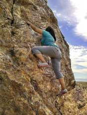 Girl climbing cliff-face